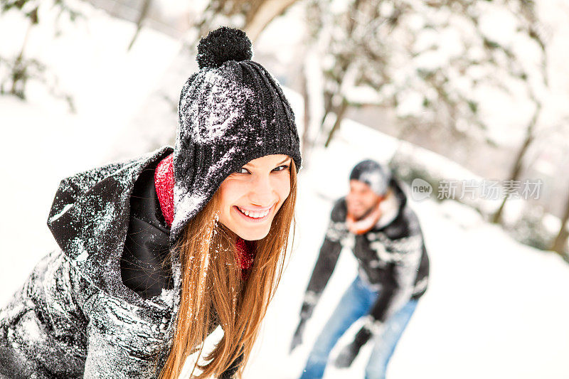 微笑的人们在雪中嬉戏
