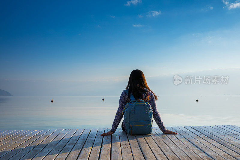 年轻女子在湖边码头休息