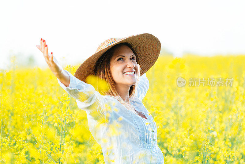 夏天，戴着草帽的油菜地里笑容可掬的妇女