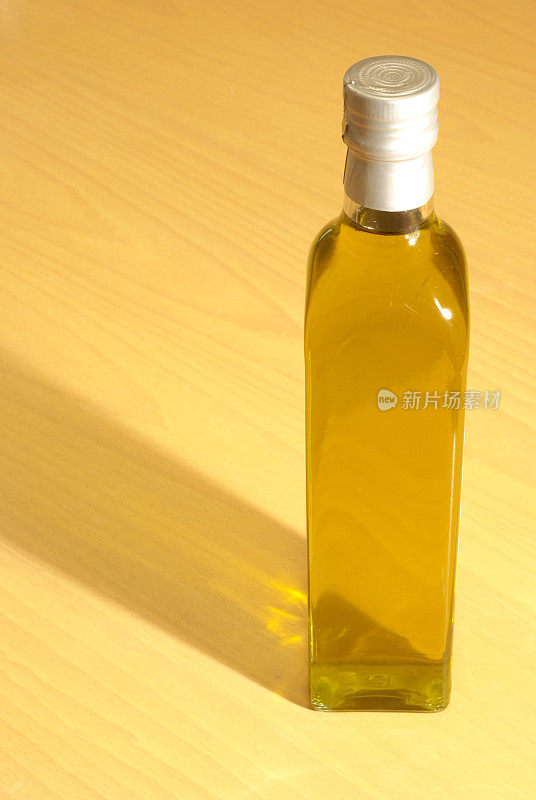 木桌上放着一瓶特级初榨橄榄油