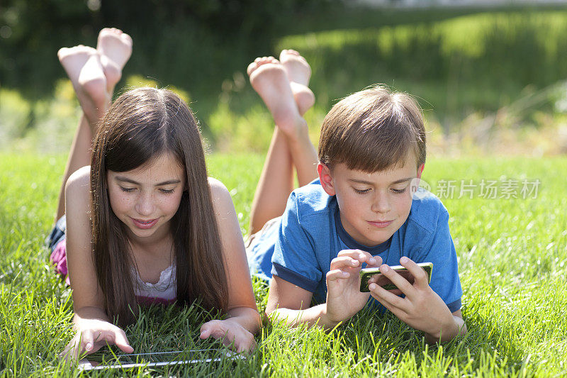 女孩和男孩在玩电子设备