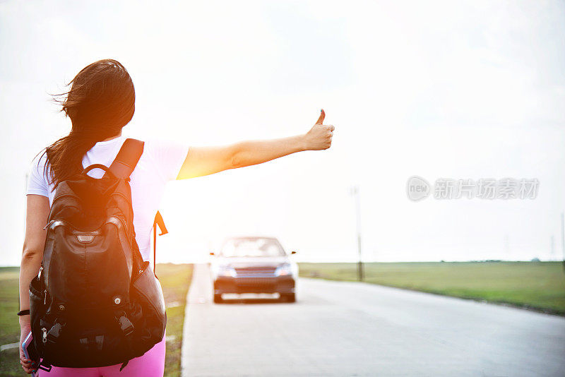 女人竖起大拇指让她搭车