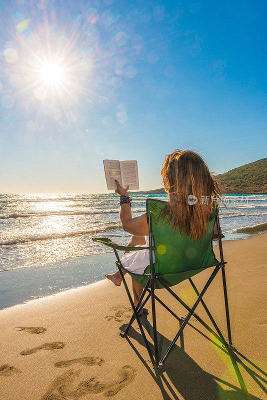 在海滩上看书的成年女性。Patara。