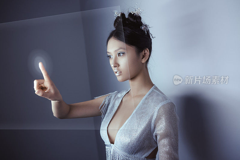 未来的概念。年轻漂亮的亚洲女人触摸数字全息图