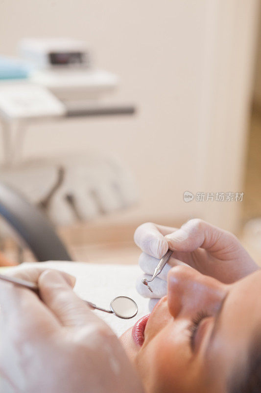 牙医在牙医的椅子上检查病人的牙齿
