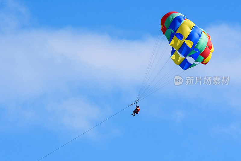 游客们在洪都拉斯罗阿坦岛的蓝天上享受滑翔运动。