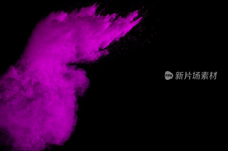 抽象的粉色粉尘爆炸在黑色背景。抽象的粉溅在黑色背景上，粉溅的冻结运动。