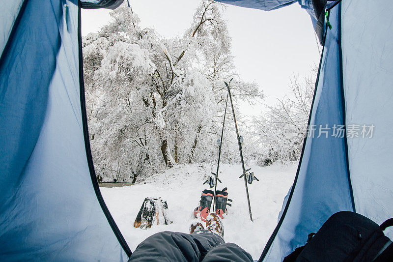 在冬天的森林里，一个人躺在帐篷里