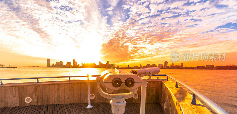 用双筒望远镜观察日落时分的新泽西市景