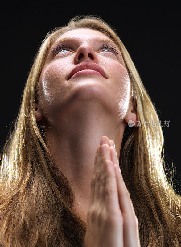 年轻的金发女人在祈祷