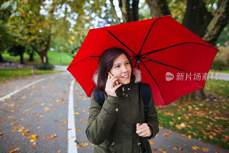 年轻女子与手机在雨天