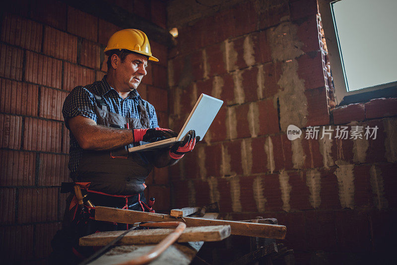 建筑工人使用笔记本电脑