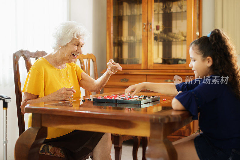 奶奶在家里和孙女玩跳棋