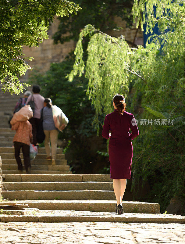 穿着中国传统旗袍的妇女在古村落里拍照