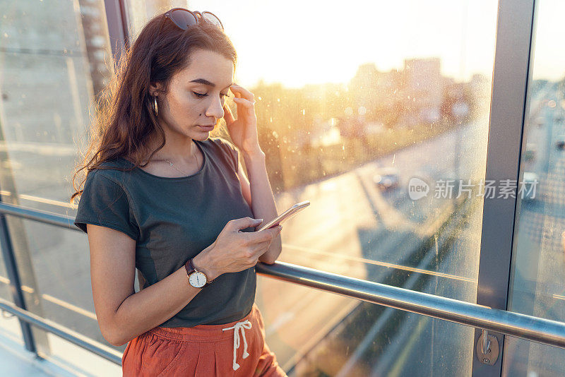 可悲的女人在城里用手机发短信