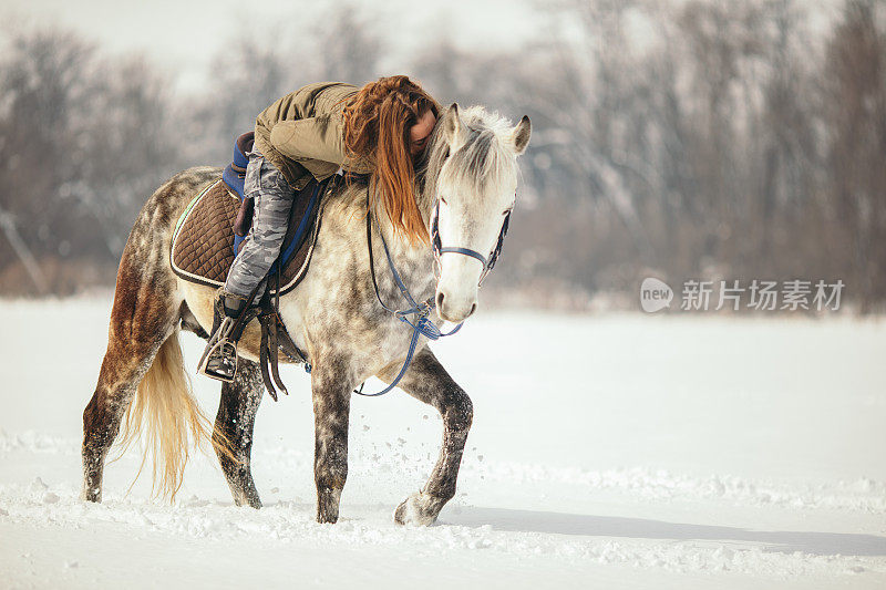 一个女人在雪地里骑马