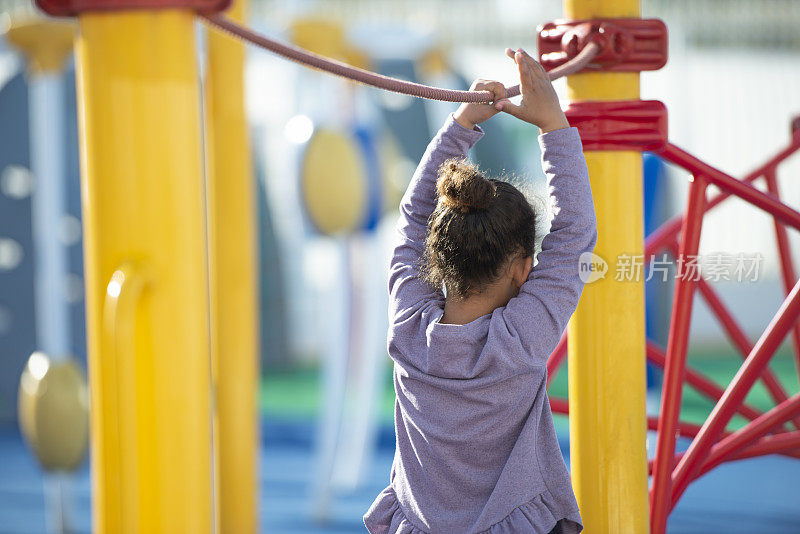 女孩在操场上学习保持平衡。