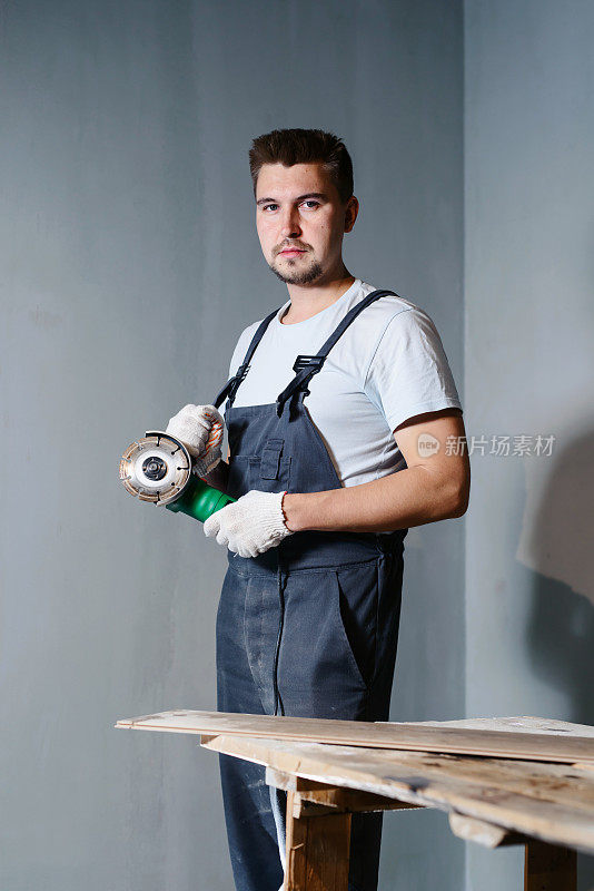 建筑工人用圆锯或砂光机的肖像。用圆锯锯木头。房子装修的概念
