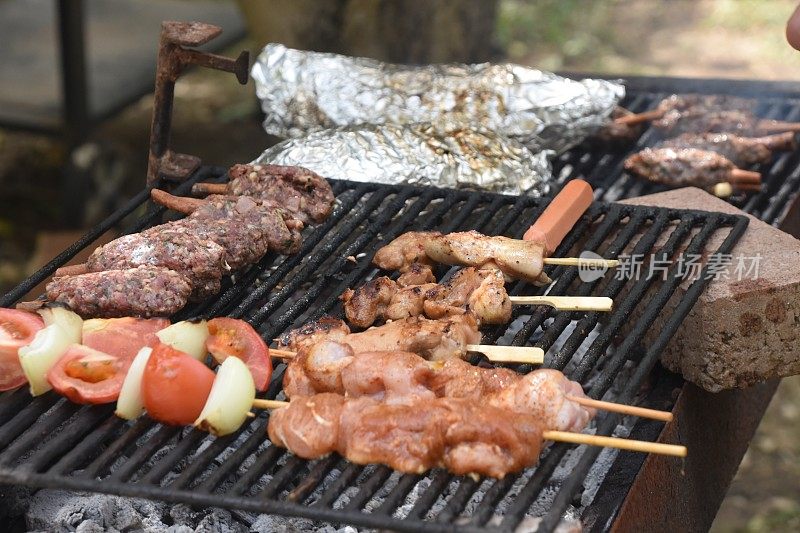 在烧烤架上烧烤食物，用手准备烤肉串