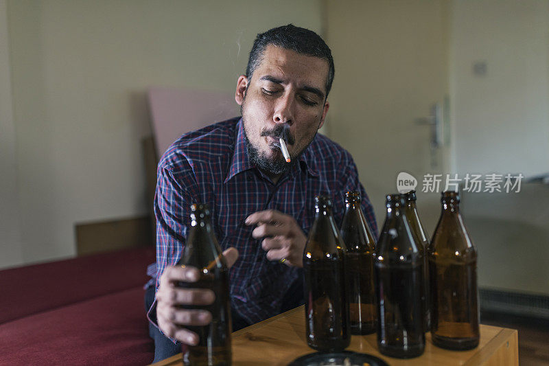 年轻悲伤的醉酒男子喝啤酒和酒精感到浪费，孤独和绝望的痛苦和情绪压力。人与酗酒、上瘾和男人抑郁的概念。