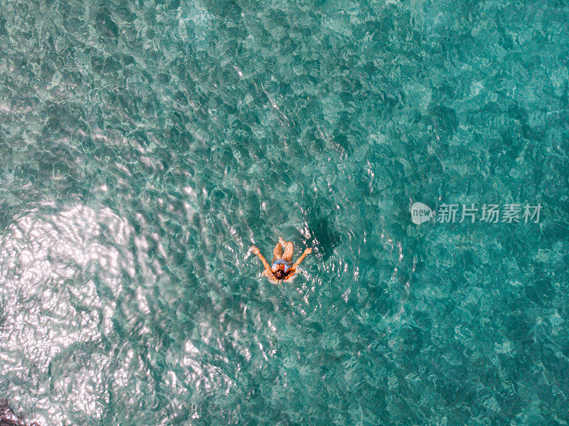 鸟瞰图女人漂浮在清澈的大海