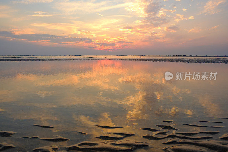 夏日海滩上的日落，海面平静