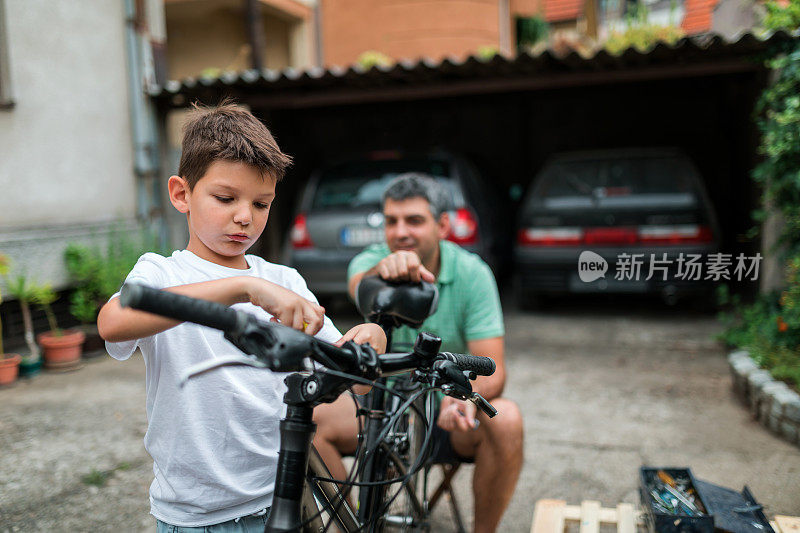 父亲看着儿子如何修理自行车