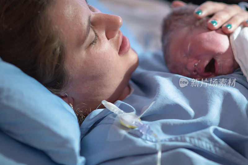 刚出生的婴儿被母亲抱在怀里