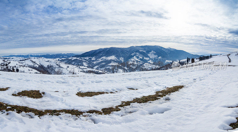 山峰上的雪被风吹走了。冬天的风景。天很冷，下着雪。