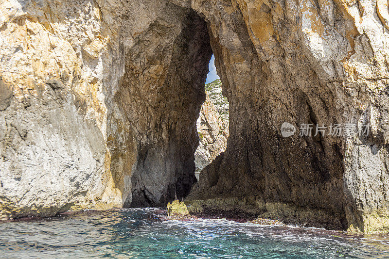 在地中海马耳他的海岸线上的蓝色洞穴旁边的海洞和岩层的观点。