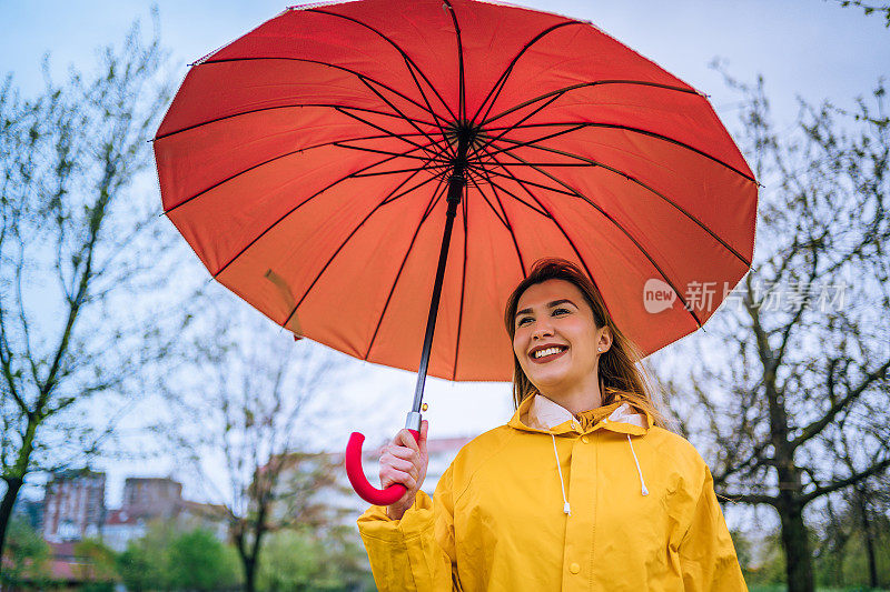 拿着红伞站在外面淋雨的女人