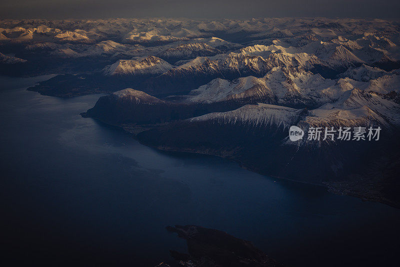 乘客从飞机上俯瞰挪威的峡湾，山上覆盖着积雪