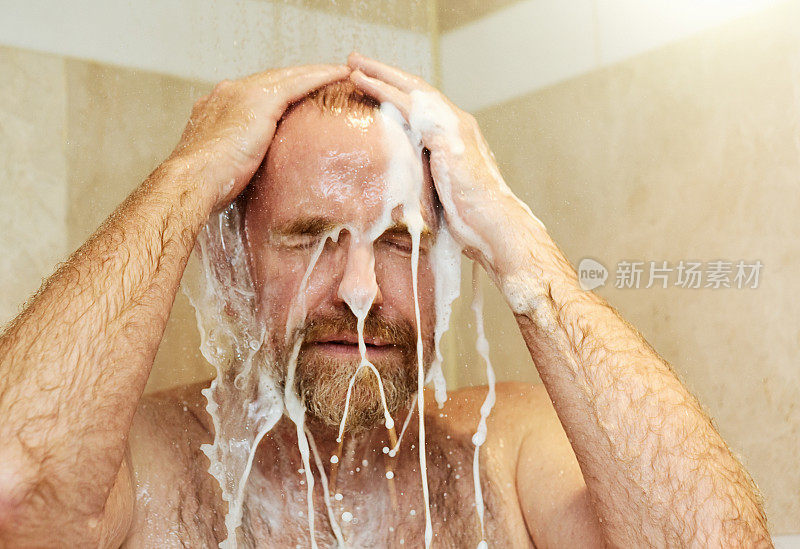 手到头上，成熟的男人在淋浴时用香波洗发