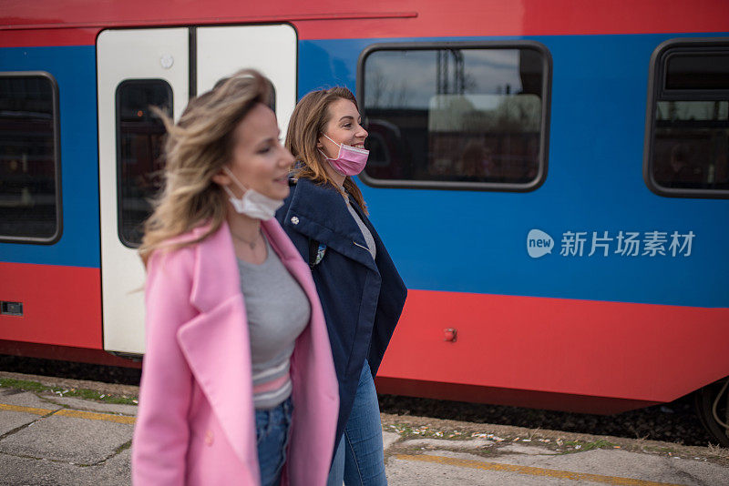 两个戴着防护面罩的妇女经过火车