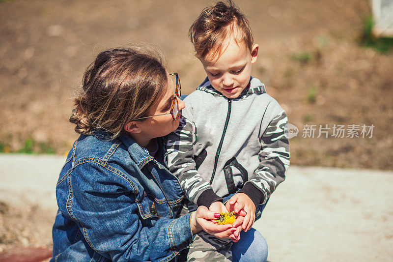 母子在大自然中采摘花草。