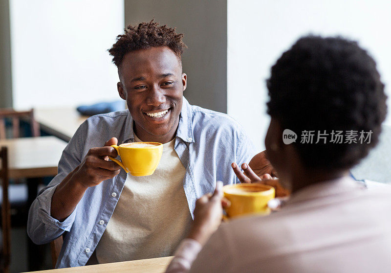 英俊的黑人男子和他的女朋友一起在城市咖啡馆喝咖啡