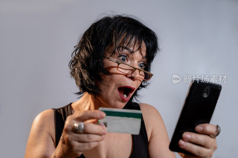 手持信用卡的困惑女性顾客对网上支付感到愤怒