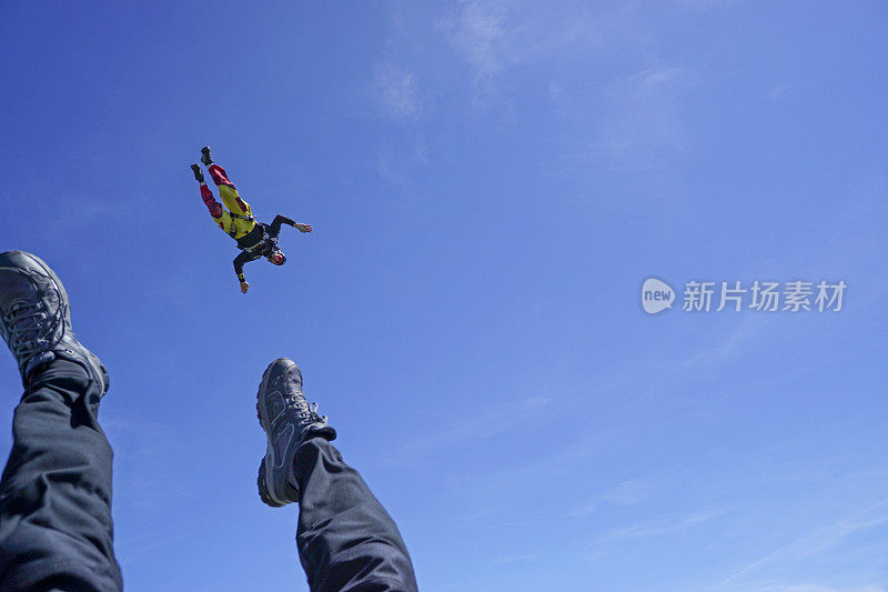 自由落体飞行者通过高山景观之上的崇高天空下降