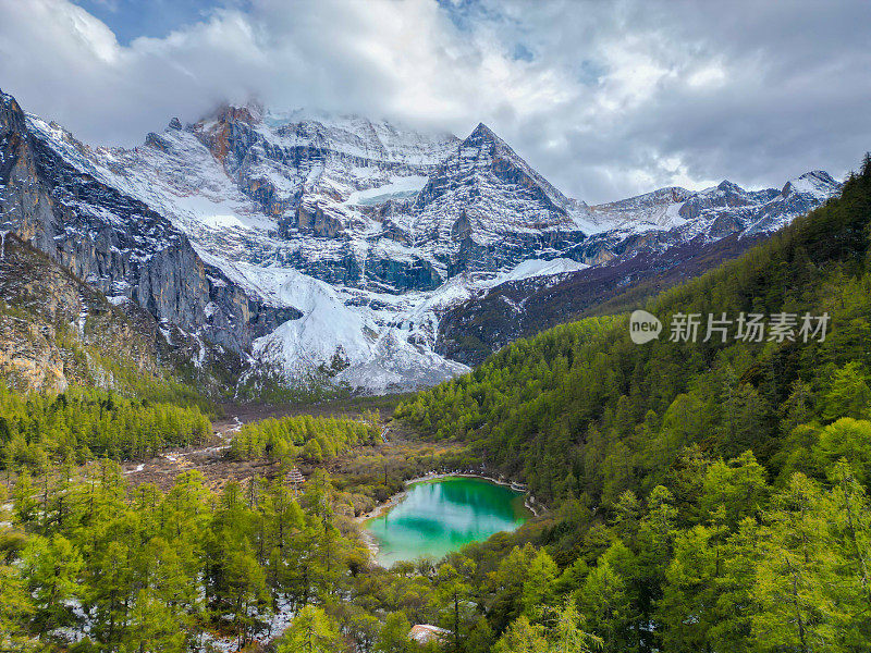中国亚丁自然保护区无人机鸟瞰图。白雪皑皑的陈若芝风景如画，四周环绕着常绿的树木和湖泊
