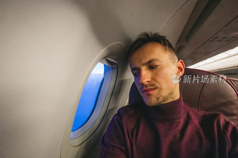 一个疲惫的年轻人在飞机上的画像