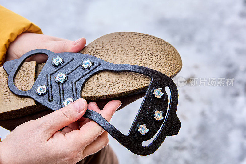 带钉鞋的防滑橡胶覆盖层附着在冬季鞋上，在结冰的条件下有更好的牵引力。