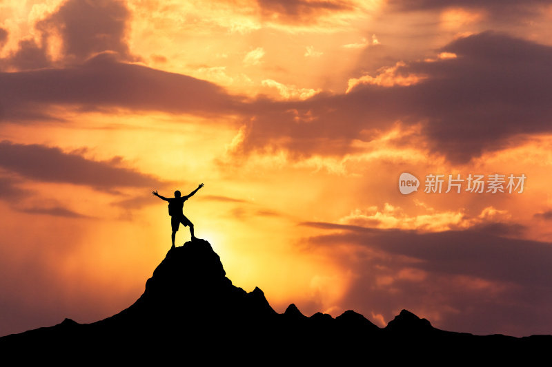 一个快乐的人站在山顶的剪影