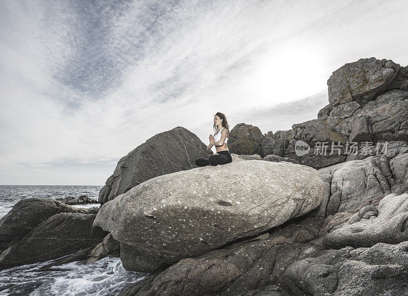 女人在瑜伽莲花pose在海上