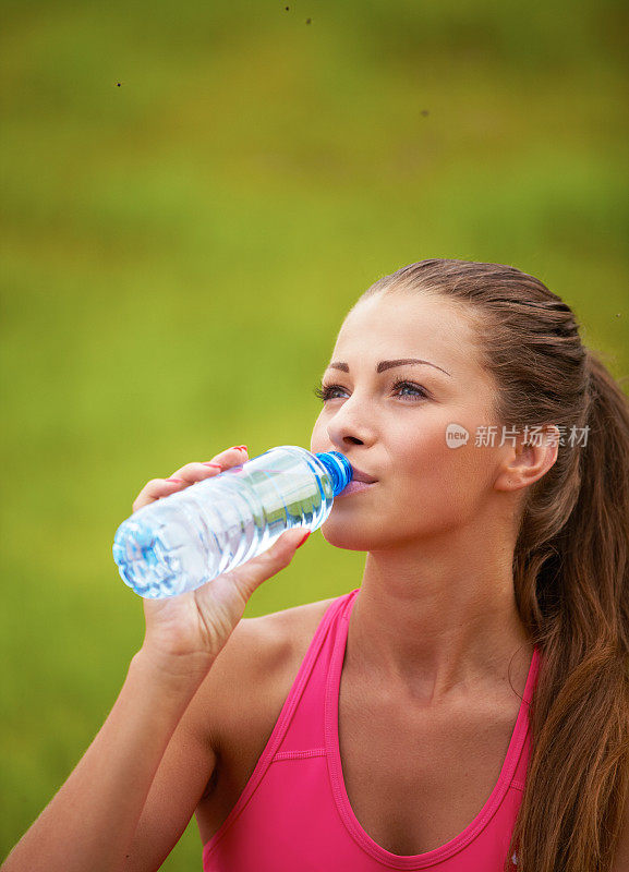 喝瓶子里水的女人