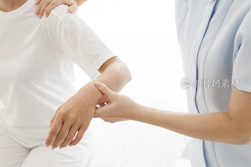 脊椎按摩师在一个房间里检查一个女人的手臂