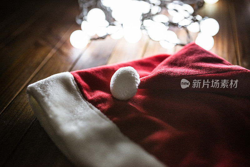 圣诞帽在木板上与圣诞灯