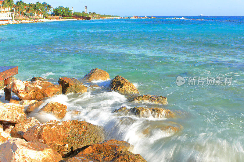 在缓慢的快门速度下，海浪撞击海滩上的岩石