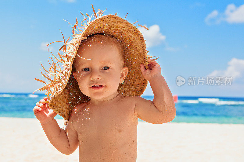 快乐的孩子与稻草在海滩上的家庭度假