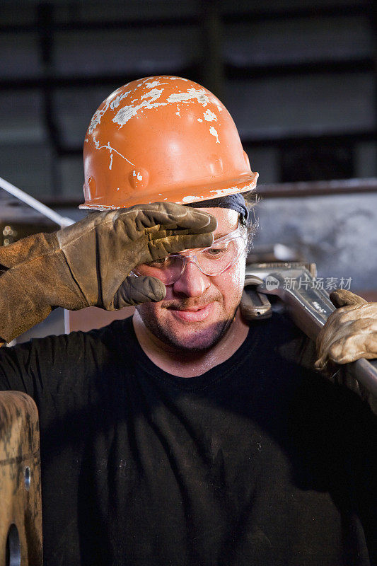 男人戴着安全帽在工厂努力工作的特写