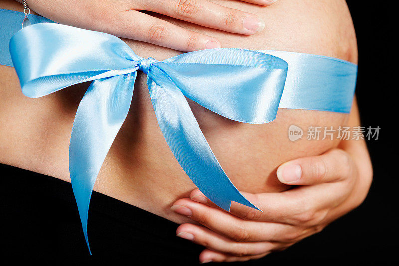 这是一个男孩!怀胎的肚子上戴着大大的蓝色蝴蝶结